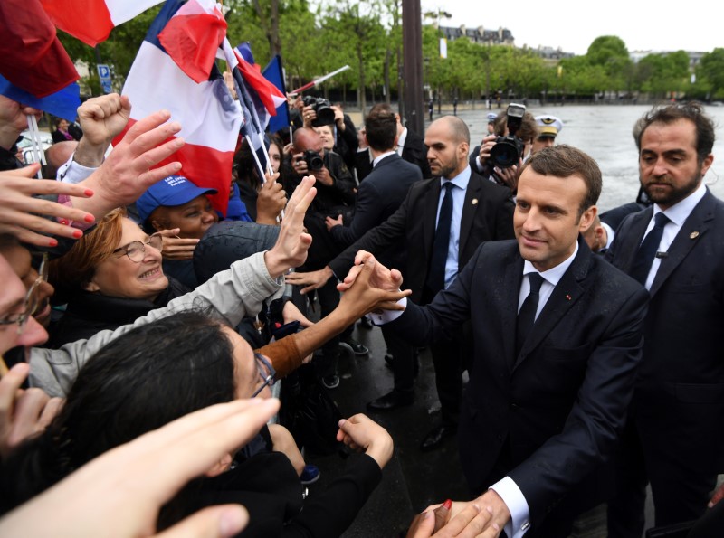 © Reuters. French President Emmanuel Macron greets people in the crowd after attending a ceremony at the Tomb of the Unknown Soldier at the Arc de Triomphe in Paris