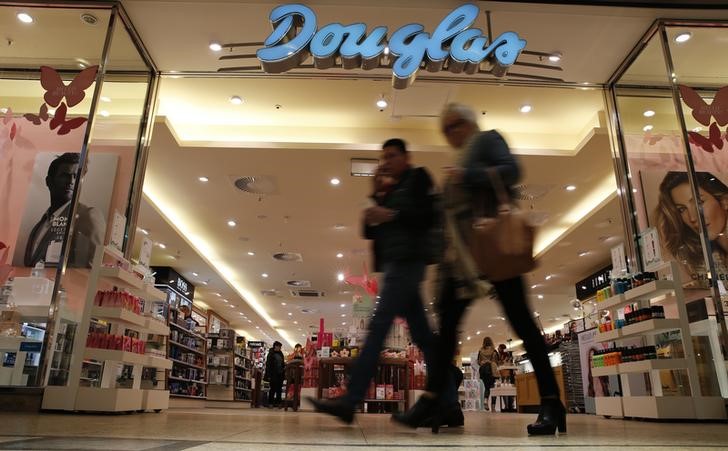 © Reuters. People pass in front of Douglas Holding AG perfume shop at a shopping mall in Magdeburg