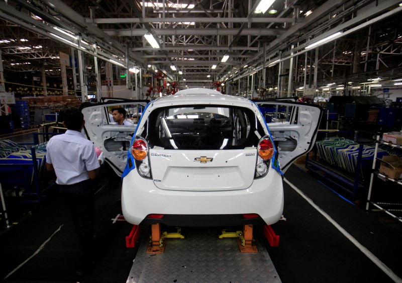 © Reuters. FILE PHOTO: Employees work on a Chevrolet Beat car on an assembly line at the General Motors plant in Talegaon