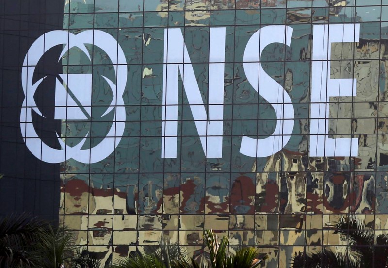 © Reuters. Buildings are reflected on the glass windows of the National Stock Exchange building in Mumbai