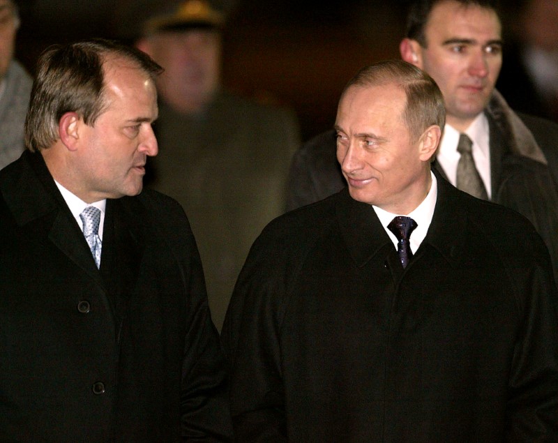 © Reuters. FILE PHOTO Russian President Putin smiles at Ukrainian President's administration head Viktor Medvedchuk as Putin arrives in Kiev in 2003