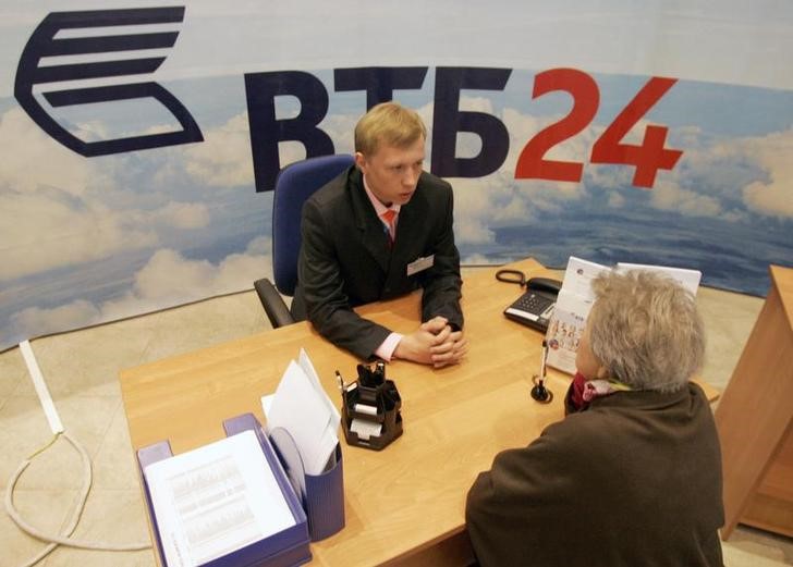 © Reuters. Employee of VTB, Russia's second-largest bank, talks to a customer at a bank office in central Moscow