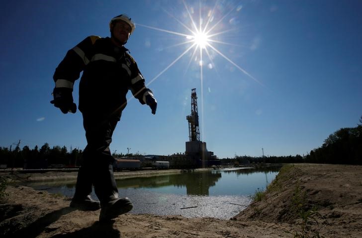 © Reuters. Worker walks past drilling rig at well pad of Rosneft-owned Prirazlomnoye oil field outside Nefteyugansk