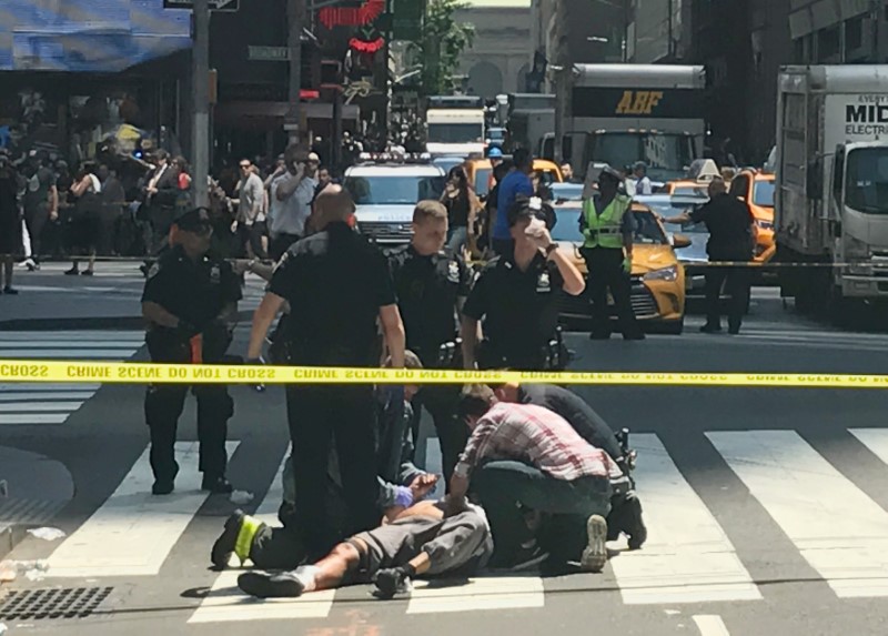 © Reuters. Socorristas e civis ajudam pedestres feridos por carro em alta velocidade na calçada da Times Square, em Nova York