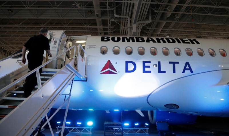 © Reuters. Workers prepare a Bombardier CS100 aircraft after a news conference announcing a contract with Delta Air Lines, at Bombardier's hangar in Mirabel