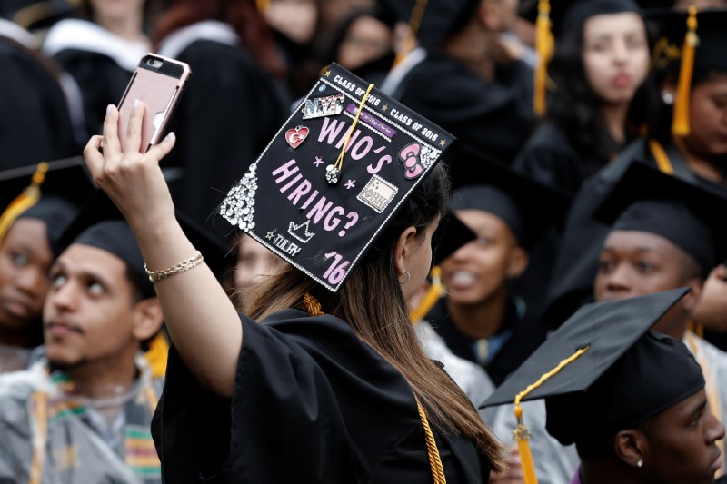 © Reuters. A graduating student of the CCNY takes a selfie of the message on her cap during the College's commencement ceremony in the Harlem section of Manhattan, New York