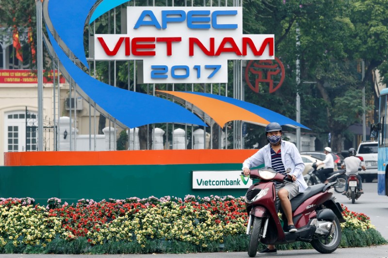 © Reuters. A motorbike waits in front of a sign promoting APEC Summit in Hanoi