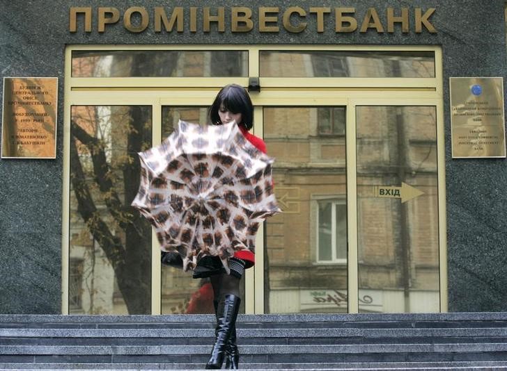 © Reuters. Женщина у офиса Проминвестбанка в Киеве