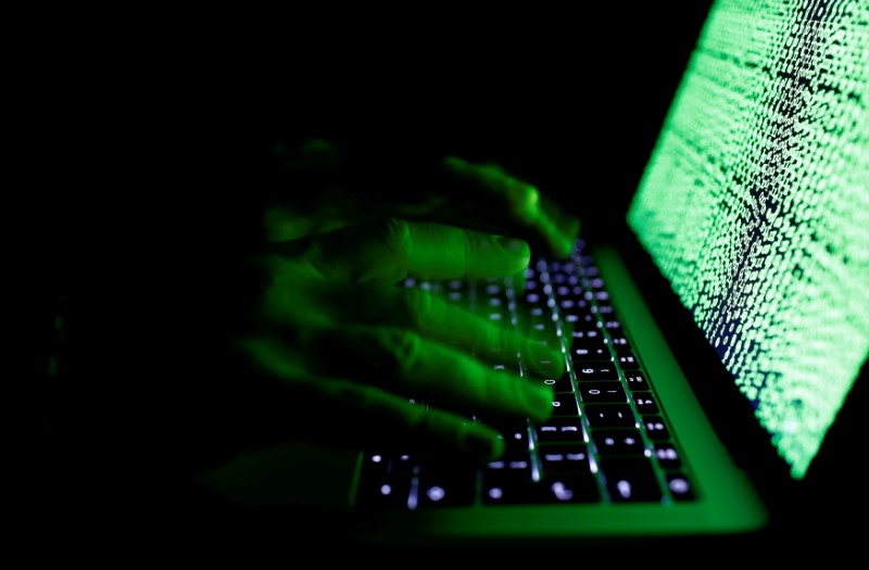 © Reuters. FILE PHOTO: Man types on a computer keyboard in front of the displayed cyber code in this illustration picture