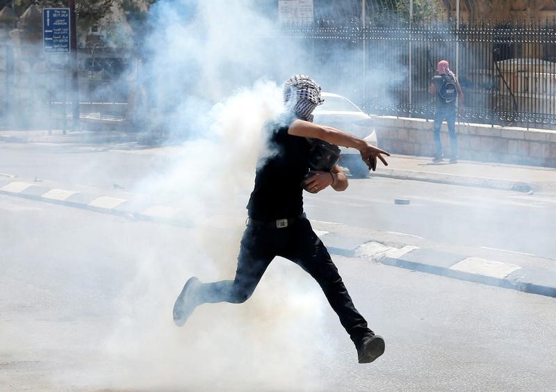 © Reuters. محتجون فلسطينيون يشتبكون مع قوات إسرائيلية في الضفة الغربية وغزة