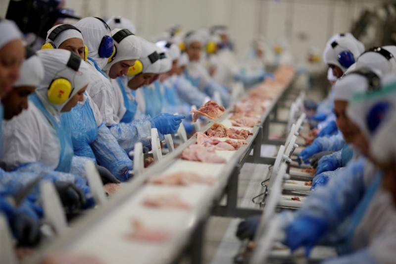 © Reuters. Employees are seen during a technical visit of Brazil's Agriculture Minister Blairo Maggi at the Brazilian meatpacker JBS SA in Lapa