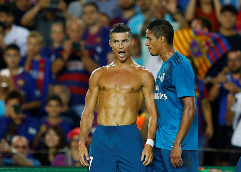 © Reuters. Cristiano Ronaldo celebra sin su camiseta junto a Raphael Varane tras anotar el segundo gol del Real Madrid en la victoria de 3-1 sobre Barcelona por la ida de la Supercopa de España
