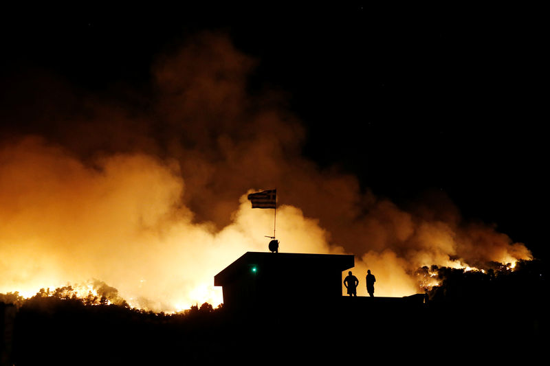 © Reuters. Los bomberos tratan de controlar un incendio cerca de Atenas