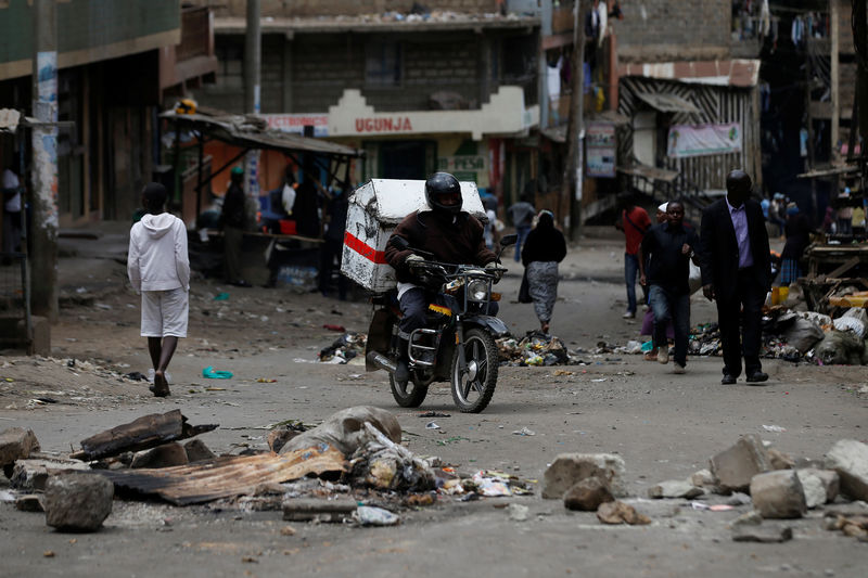 © Reuters. A motorcycle driver manouvres through obstacles placed on a street by supporters of opposition leader Raila Odinga during the latest protests in Mathare