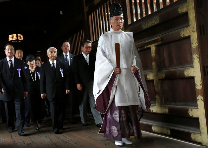 © Reuters. A group of lawmakers including Japan's ruling Liberal Democratic Party lawmaker Hidehisa Otsuji are led by a shinto priet as they offer prayers for the war dead at the Yasukuni Shrine in Tokyo