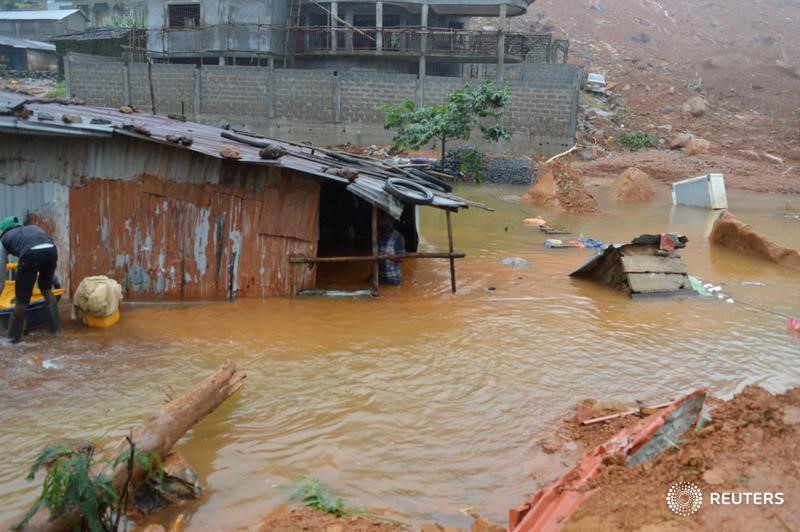 © Reuters. Residents save belongings in floodwaters after a mudslide in the mountain town of Regent