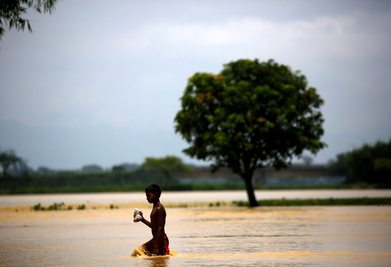 © Reuters. A boy walks along the flooded area in Saptari District