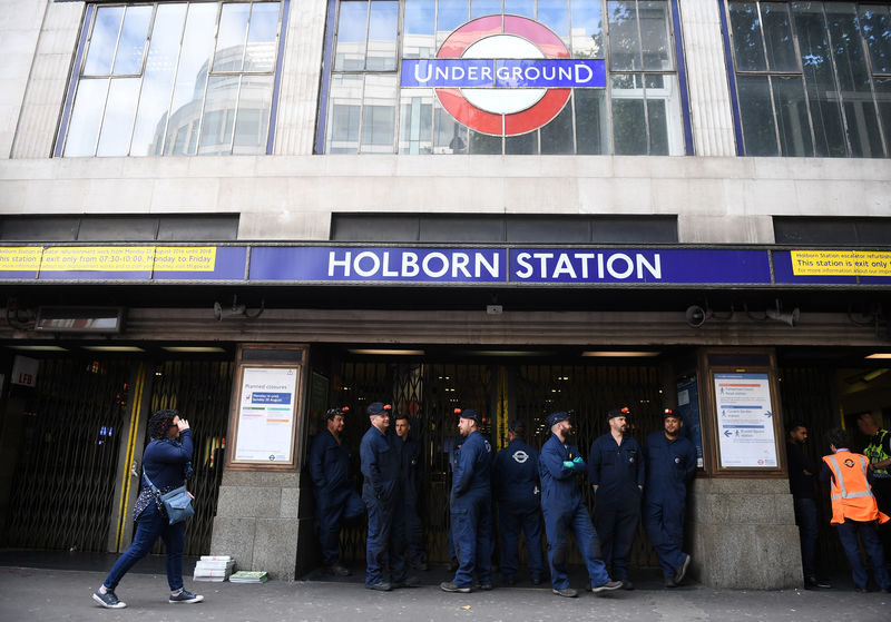 © Reuters. London Underground workers stand outside Holborn Station, that was temporarily closed following a fire alert, in central London