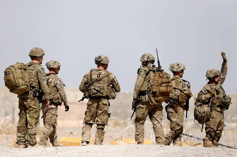 © Reuters. FILE PHOTO - U.S. troops walk outside their base in Uruzgan province