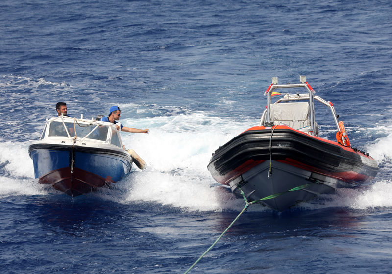 © Reuters. Anti-immigration activists aboard a speed craft try to place "Defend Europe" stickers on a RHIB of the Proactive Open Arms rescue charity in the Western Mediterranean Sea