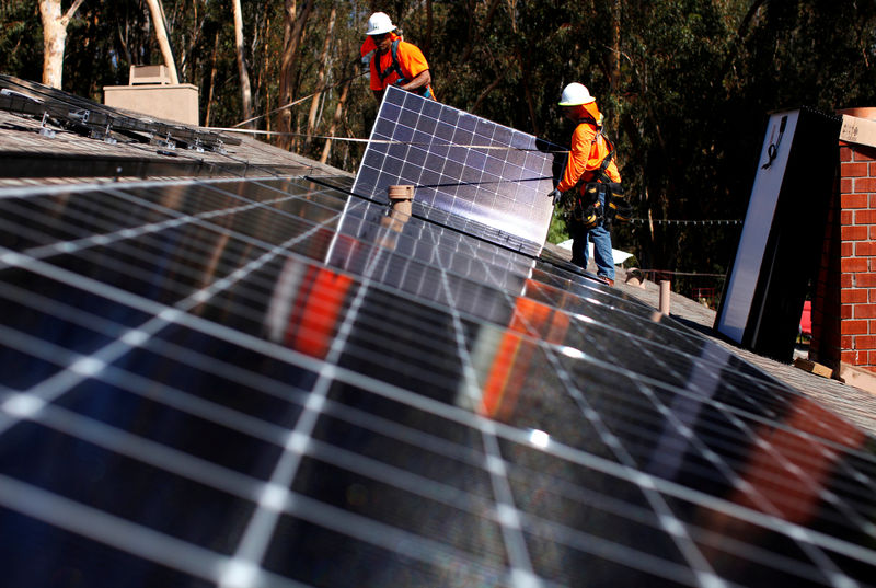 © Reuters. FILE PHOTO: Solar installers from Baker Electric place solar panels on the roof of a residential home in Scripps Ranch, San Diego