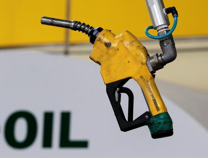 © Reuters. FILE PHOTO - A gas pump is seen hanging from the ceiling at a petrol station in Seoul