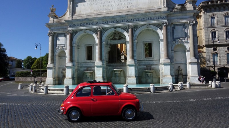 © Reuters. A man drives an old Fiat 500 past the monumental fountain Dell'Acqua Paola known as " Big Fountain" in Rome