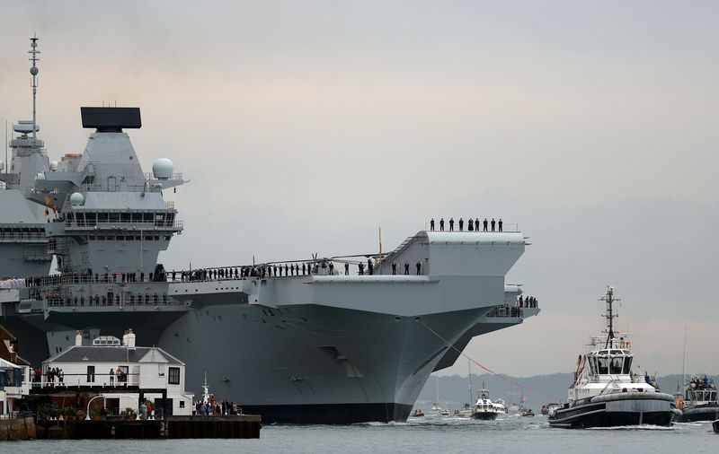 © Reuters. The Royal Navy's new aircraft carrier, HMS Queen Elizabeth, is towed by tugs as it arrives at Portsmouth Naval base, its new home port, in Portsmouth