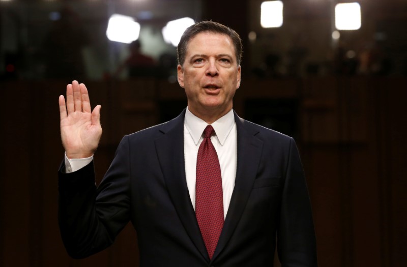 © Reuters. FILE PHOTO: Former FBI Director James Comey sworn in to testify at a hearing in Washington