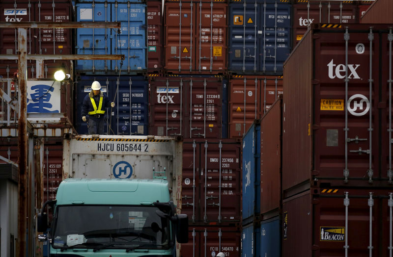 © Reuters. FILE PHOTO -  A laborer works in a container area at a port in Tokyo