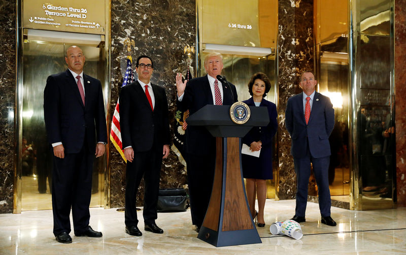 © Reuters. President Trump is flanked by staff and cabinet members as he speaks about the Charlotte violence in New York