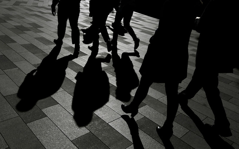 © Reuters. FILE PHOTO -  Workers cast shadows as they stroll among the office towers Sydney's Barangaroo business district in Australia's largest city