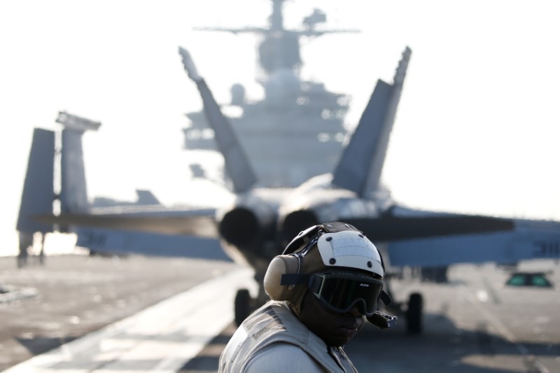 © Reuters. A U.S. Navy crew member looks at a F/A-18 Super Hornet fighter as it prepares for take off from the USS Ronald Reagan during a joint naval drill between South Korea and the U.S., in the West Sea