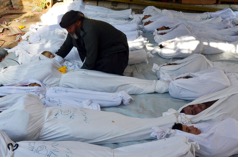 © Reuters. FILE PHOTO: Man holds the body of a dead child among bodies of people activists say were killed by nerve gas in the Ghouta region, in the Duma neighbourhood of Damascus