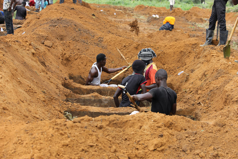 © Reuters. Workers are seen digging graves at Paloko cemetery in Waterloo