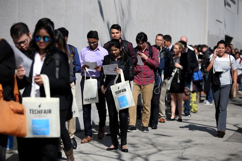 © Reuters. FILE PHOTO: People wait in line to attend TechFair LA, a technology job fair, in Los Angeles