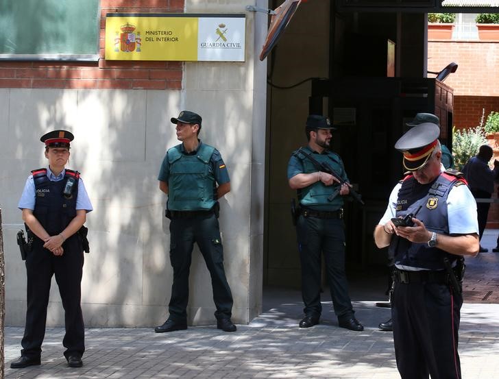 © Reuters. FILE PHOTO: Mossos d'Esquadra officers (Catalan Regional Police) stand guard in front of Civil Guard headquarters during a protest in Barcelona