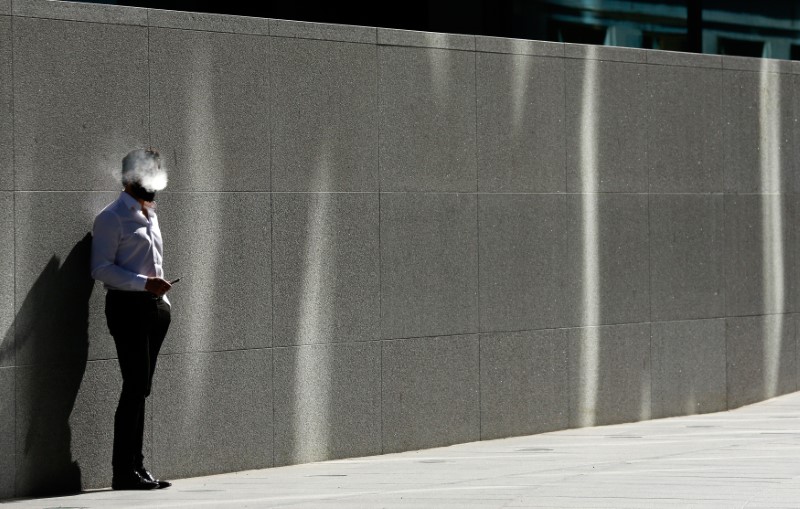 © Reuters. A man uses an electronic cigarette on a sunny spring day in London