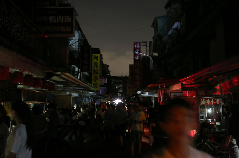 © Reuters. People walk on a street during a massive power outage in Taipei