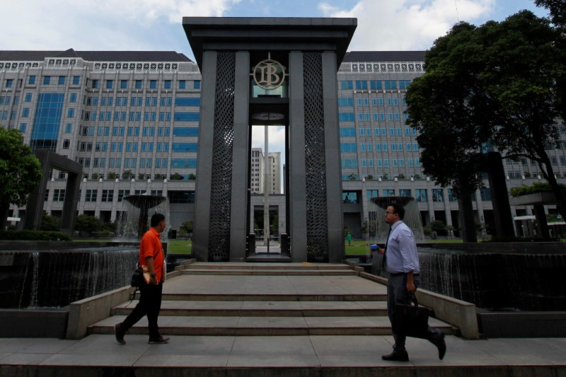 © Reuters. People walks near the fountain of Indonesia's central bank, Bank Indonesia, in Jakarta