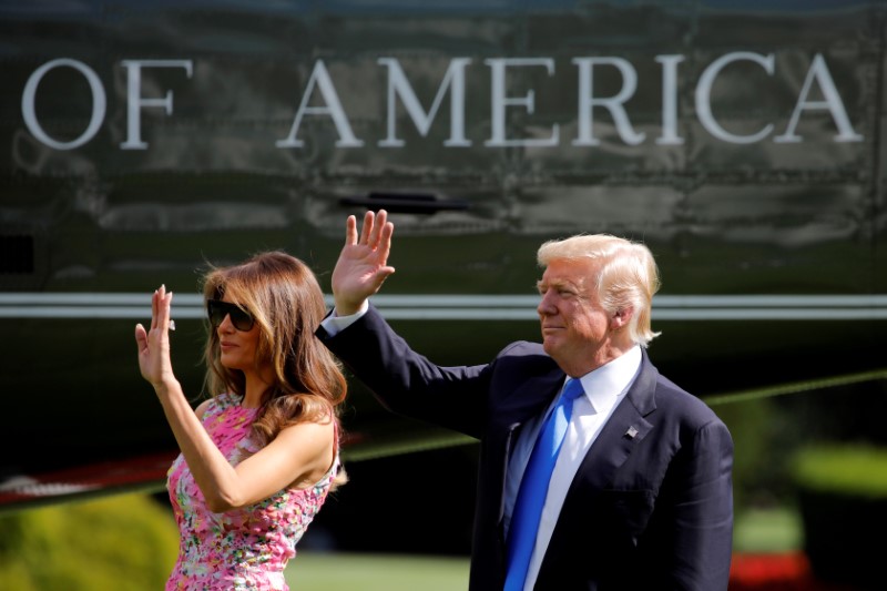 © Reuters. FILE PHOTO - President Donald Trump and first lady Melania Trump wave as they leave the White House in Washington