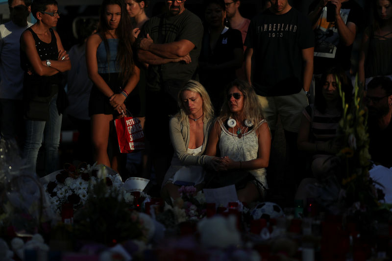 © Reuters. People react at an impromptu memorial where a van crashed into pedestrians at Las Ramblas in Barcelona