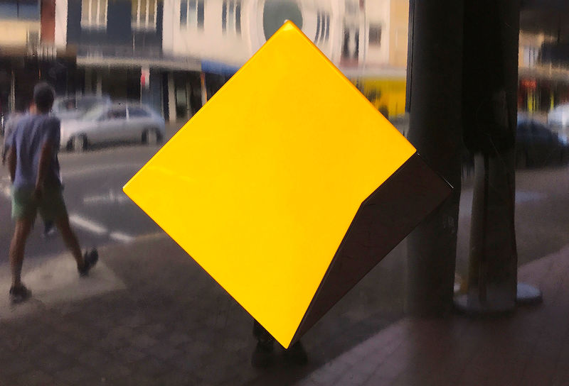 © Reuters. A pedestrian walks past a logo for the Commonwealth Bank located outside a branch in Sydney, Australia