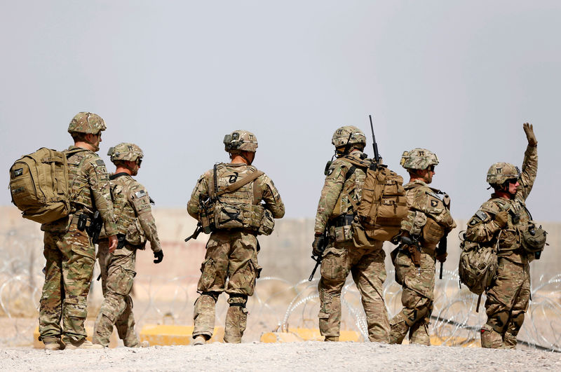 © Reuters. FILE PHOTO: U.S. troops walk outside their base in Uruzgan province