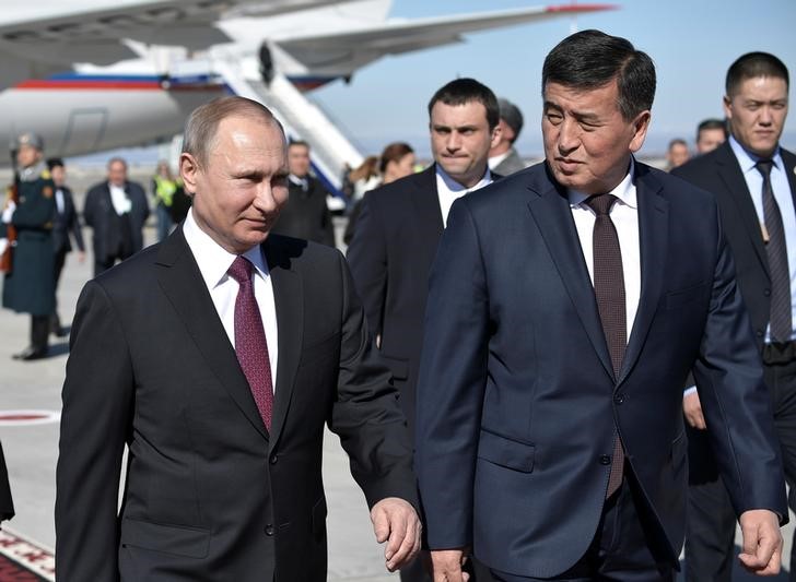 © Reuters. Премьер-министр Киргизии Сооронбай Жээнбеков с президентом РФ Владимиром Путиным на авиабазе Манас под Бишкеком