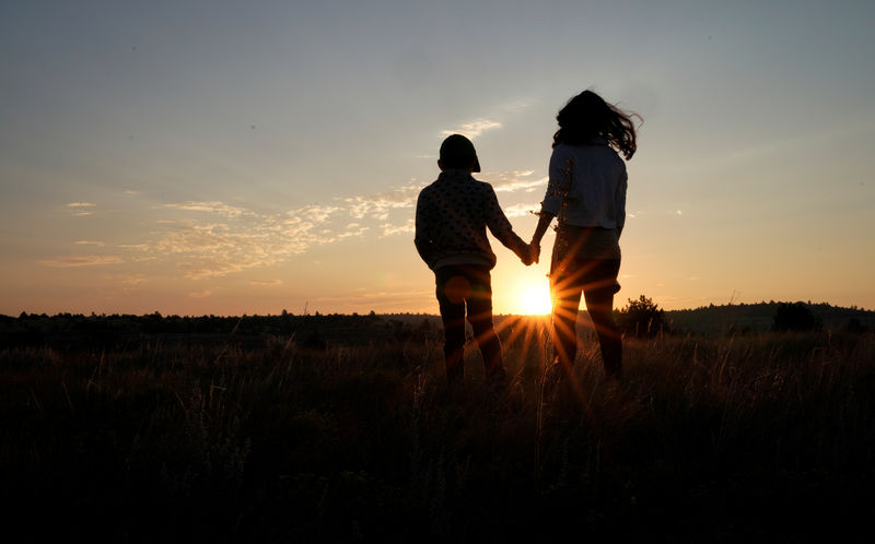 © Reuters. Lauren Coria-Avila e sua filha Sielh Avila observam o nascer do sol, enquanto esperam pelo eclipse solar em Guernsey, Wyoming, nos Estados Unidos