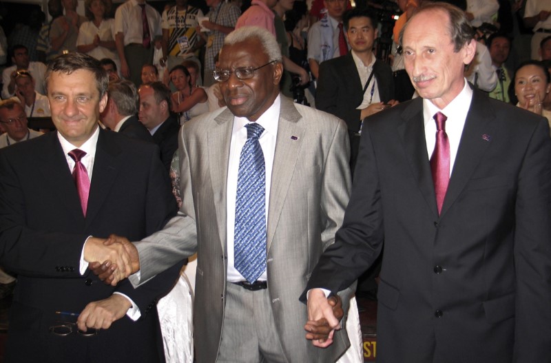 © Reuters. IAAF President Diack holds hands with Russia's Balakhnichev and Vinogradov in Mombasa