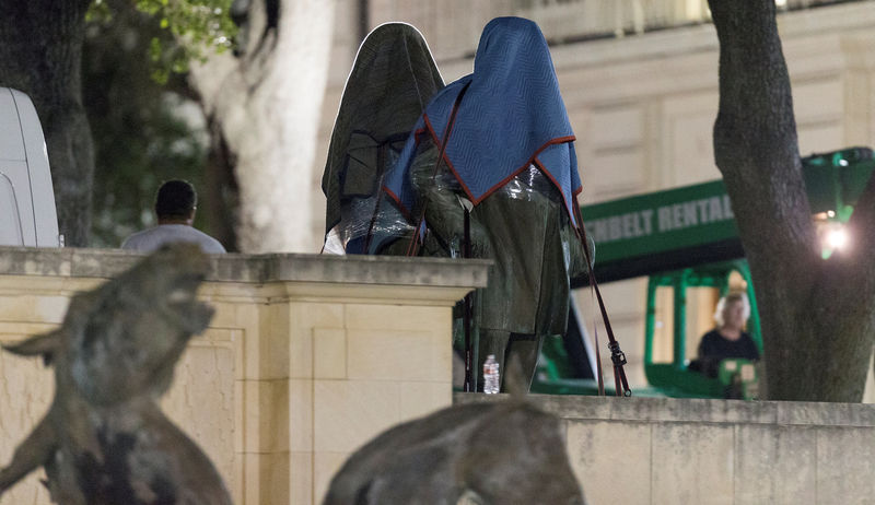 © Reuters. Workers remove Texas Governor James Stephen Hogg and Confederate Postmaster General John Reagan statues from the south mall of the University of Texas in Austin