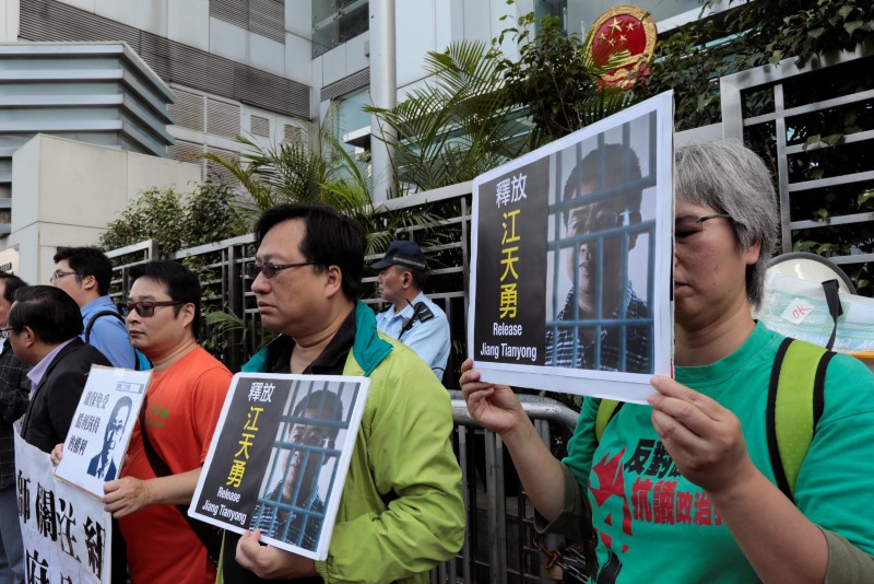 © Reuters. FILE PHOTO - Pro-democracy demonstrators hold up portraits of Chinese disbarred lawyer Jiang Tianyong, demanding his release, during a demonstration outside the Chinese liaison office in Hong Kong