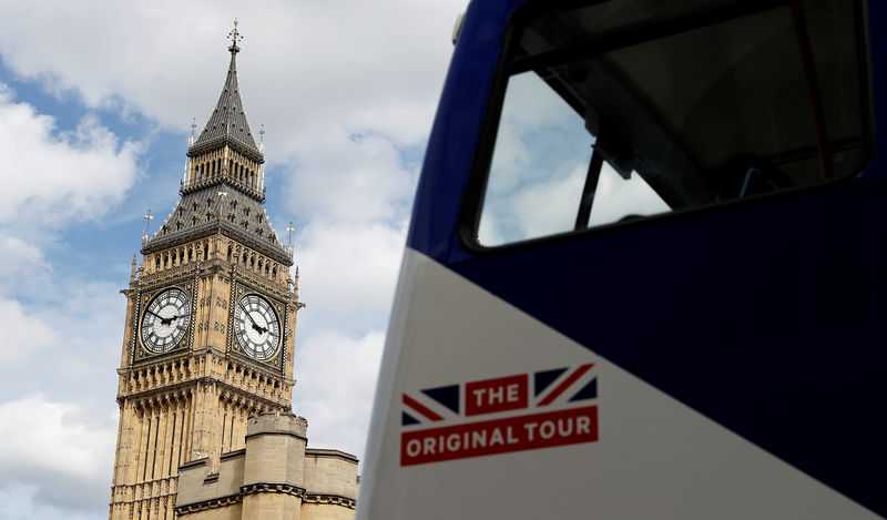 © Reuters. A tourist bus passes the Queen Elizabeth Tower, which houses the Great Clock and the 'Big Ben' bell, at the Houses of Parliament in London